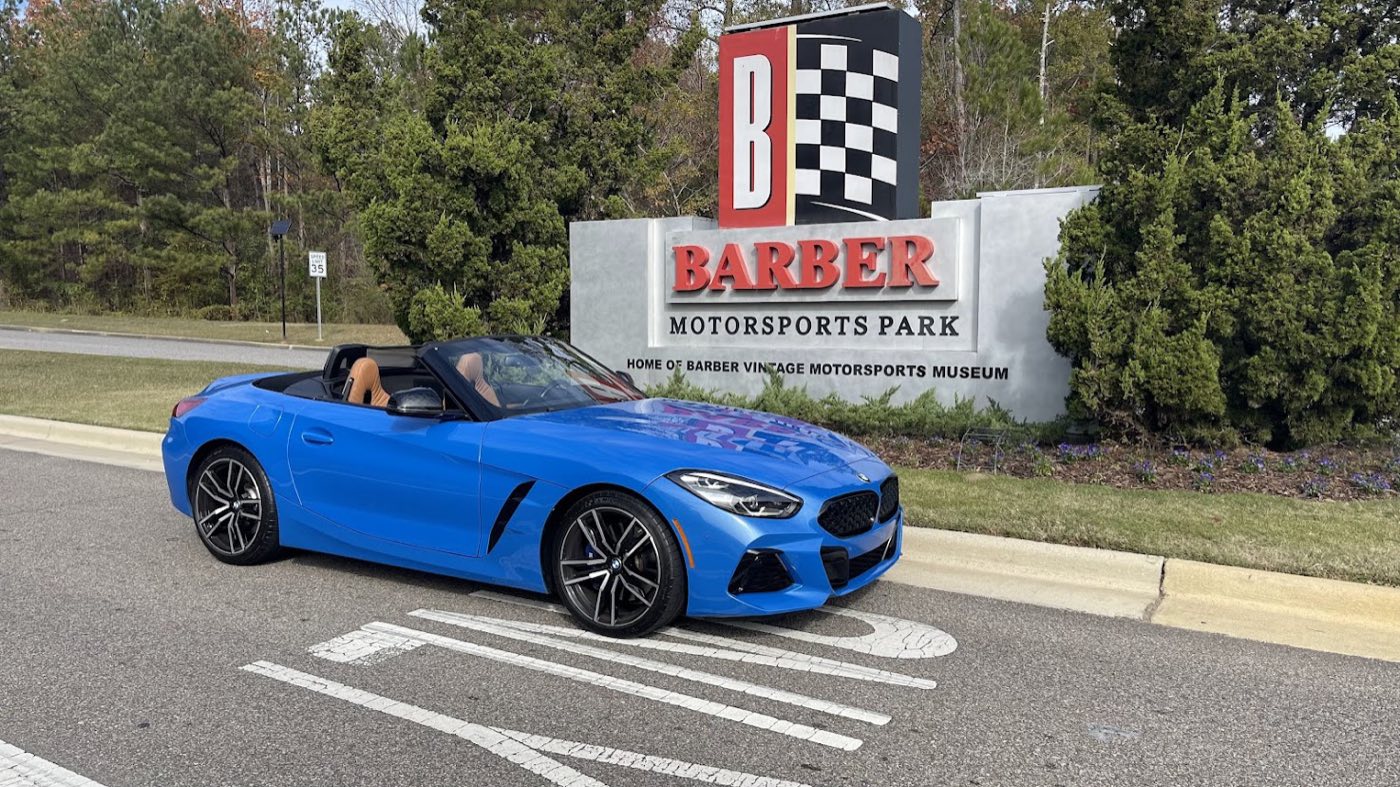 Bill's blue Z4 M40i parked in front of the Barber Motorsports Park entrance sign