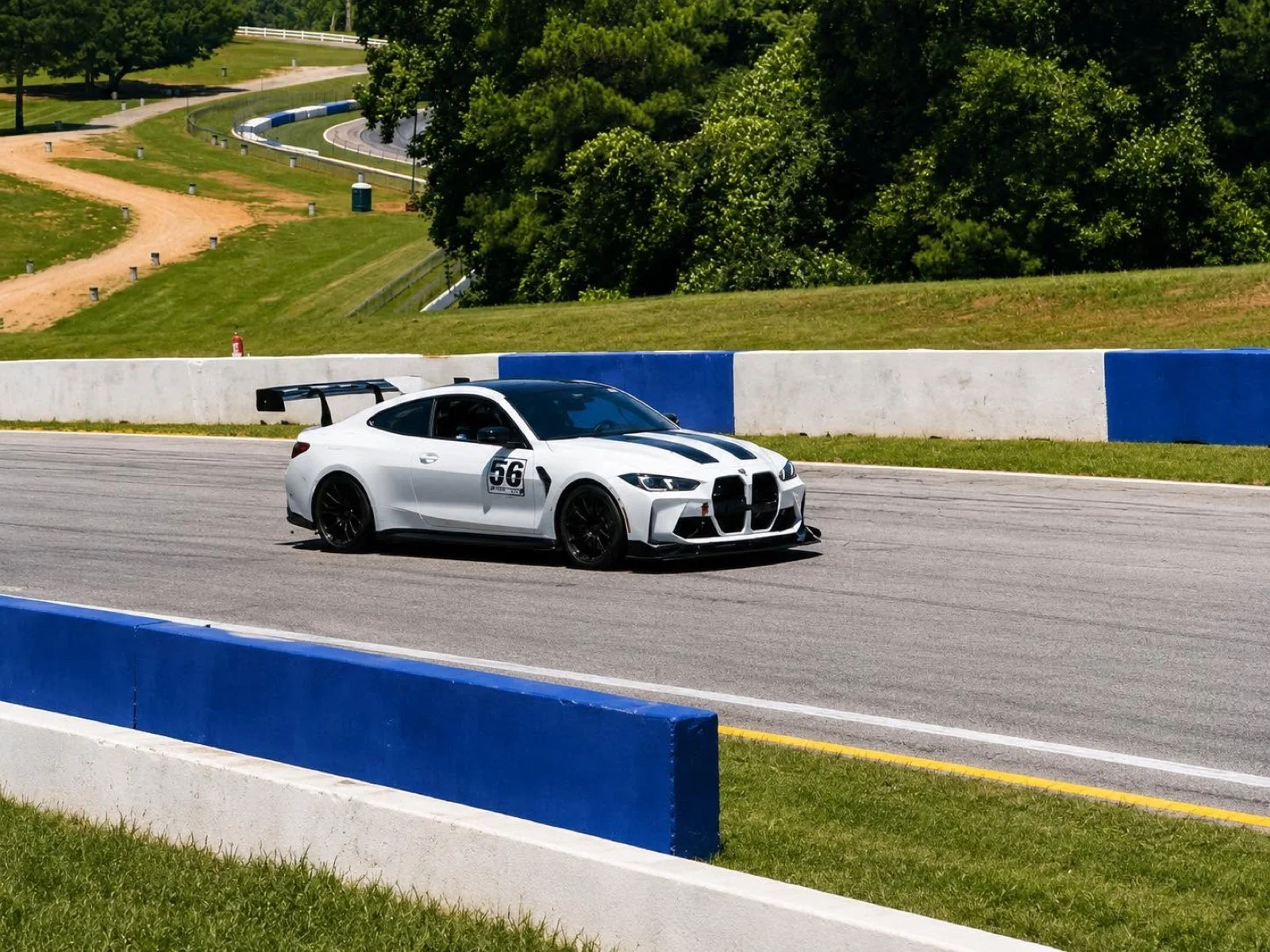 JD's white BMW M4 Competition on track at Road Atlanta, carrying the number 56, with a large rear wing