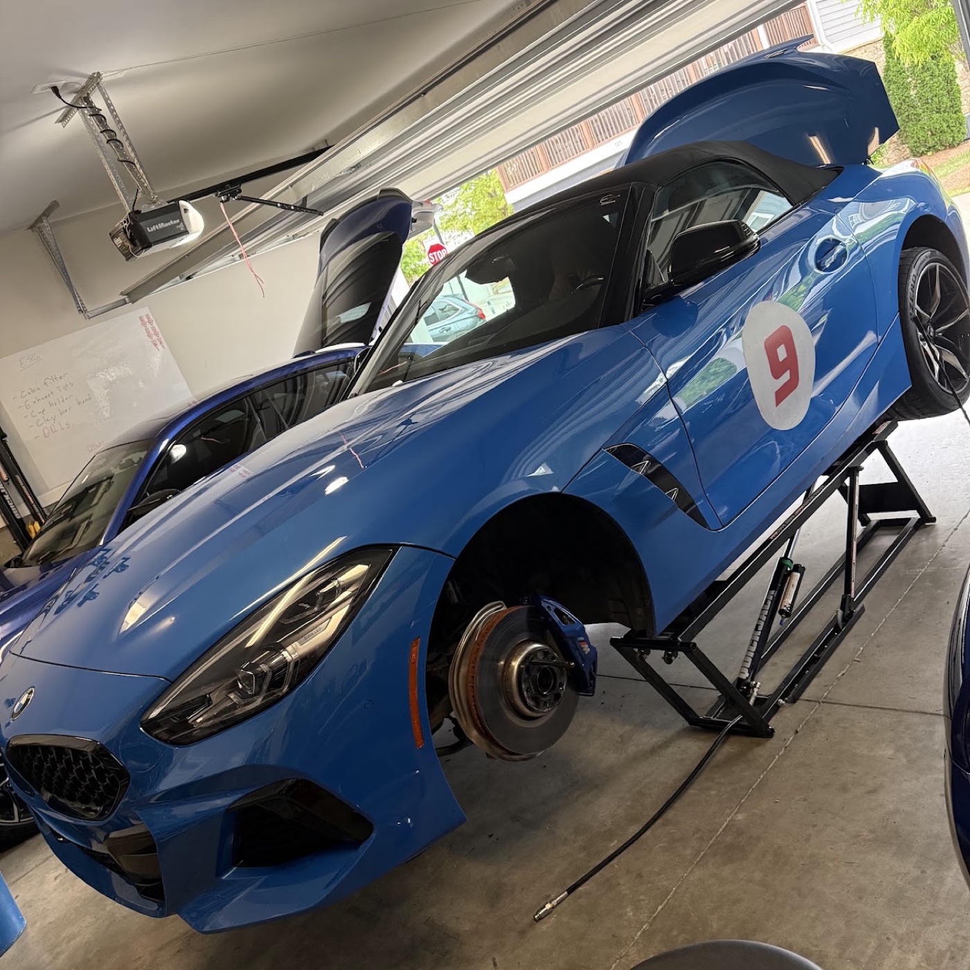 The G29 up on the QuickJack with a front wheel off, the E86 Coupe in the next bay