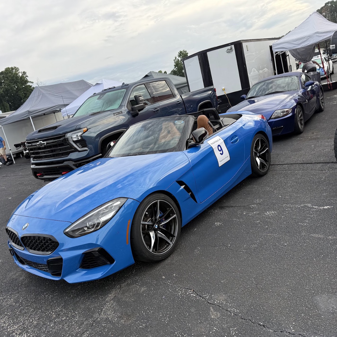 Two Z4s nose to tail in the paddock — the G29 M40i and the E86